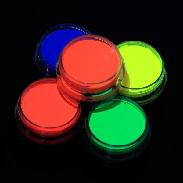 Five small jars of vibrant neon UV-reactive face and body paint in pink, yellow, green, blue, and orange on black.
