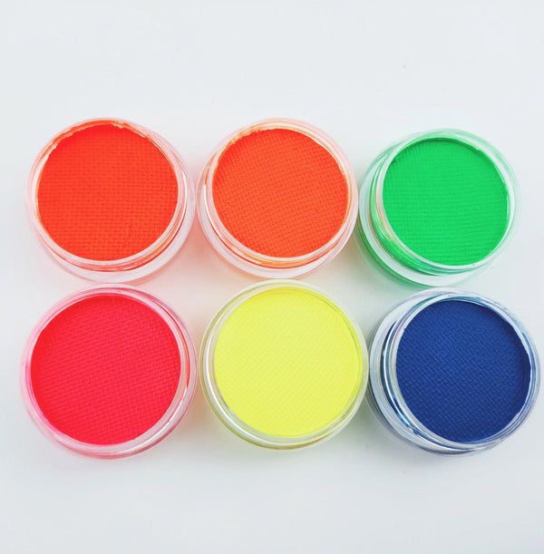 Six small jars of vibrant, UV-reactive neon face and body paint in red, orange, green, pink, yellow, and blue.