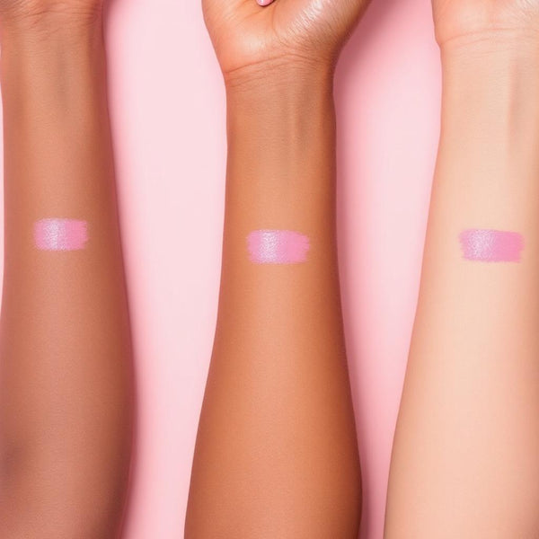 Bright pink UV vegan paint liner swatch applied to three different skin tones on a light pink background.