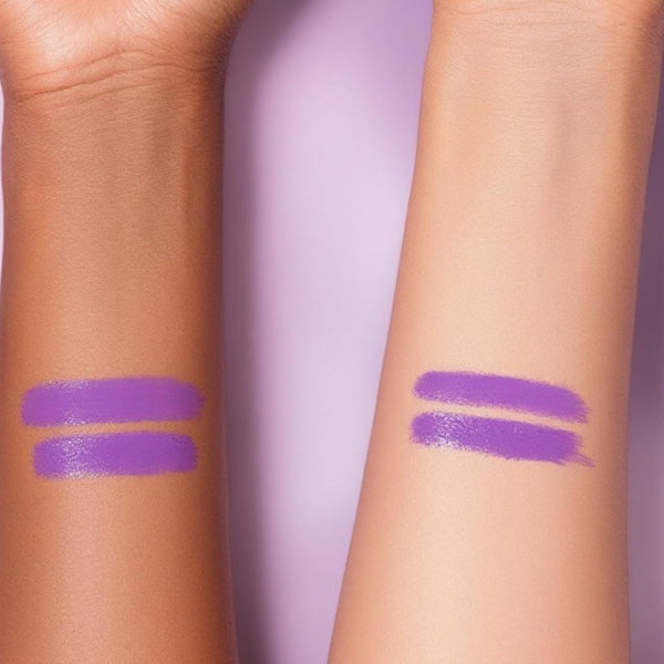 Two vibrant purple UV vegan paint liner swatches on light and dark skin tones against a soft lavender background.